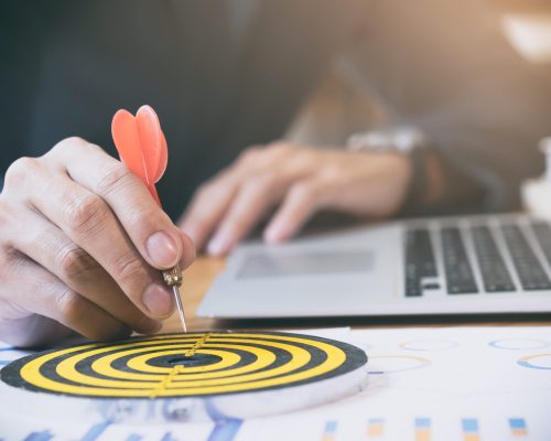 Businessman holding red dart push on target. Business strategy planning success target goals. Business development concept